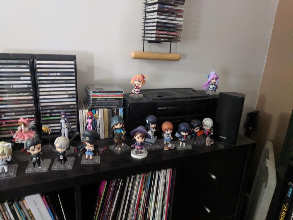 Shelf top with anime figures, cassette boombox, CDs